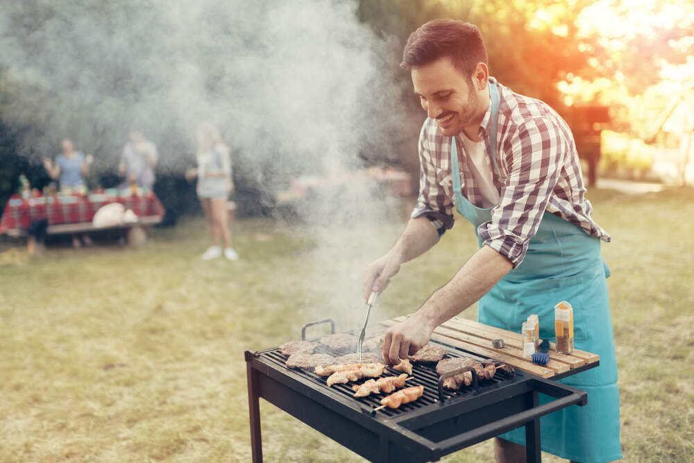 young man grilling in the backyard