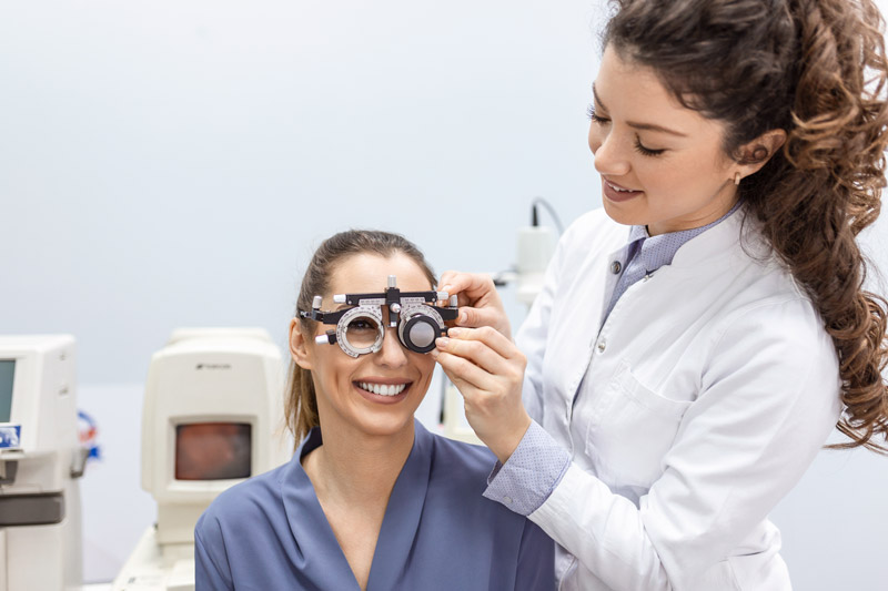 Smiling woman having an eye exam performed