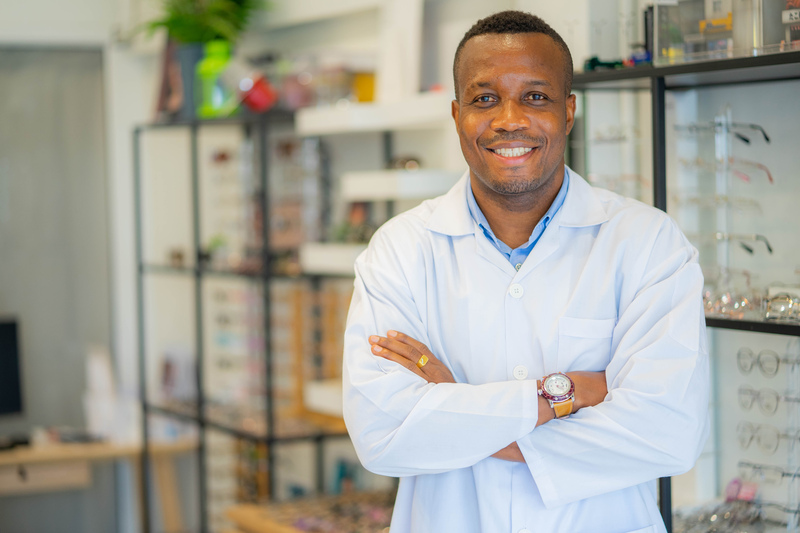 Optometrist posing in front of selection of glasses