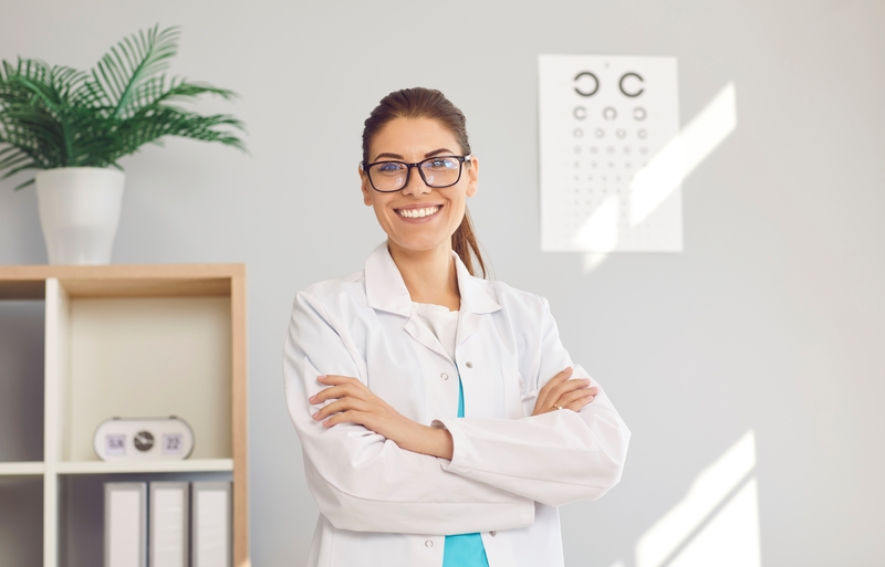 Woman eye doctor posing in her office