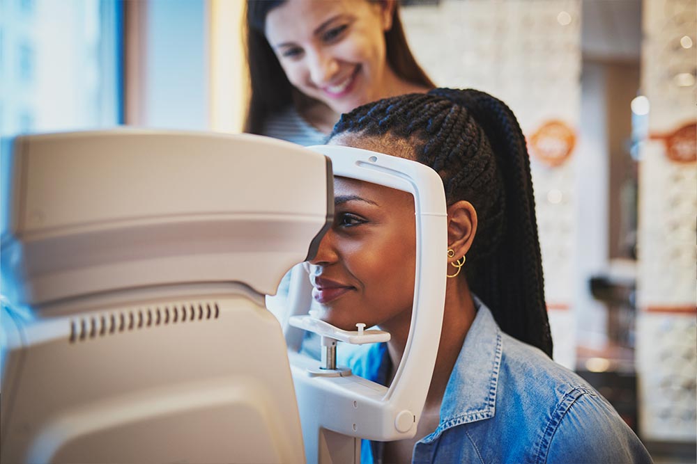 Woman having an eye exam performed while Optometrist watches