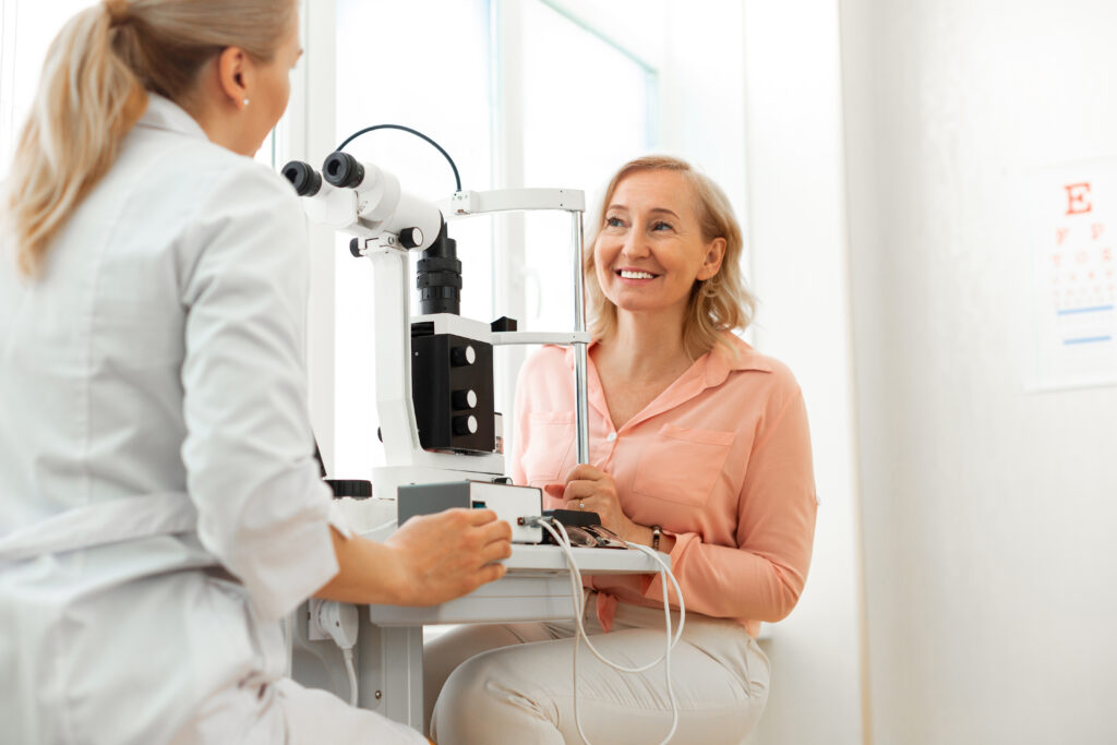 patient with wide smile having pleasant conversation with blonde doctor