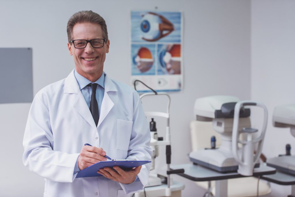 Smiling doctor standing in his office