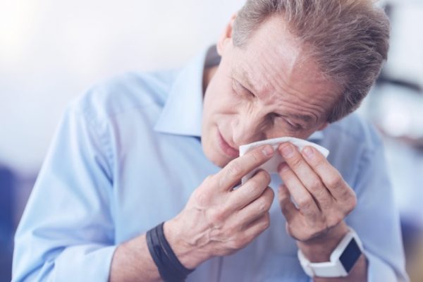 Man wiping his eyes